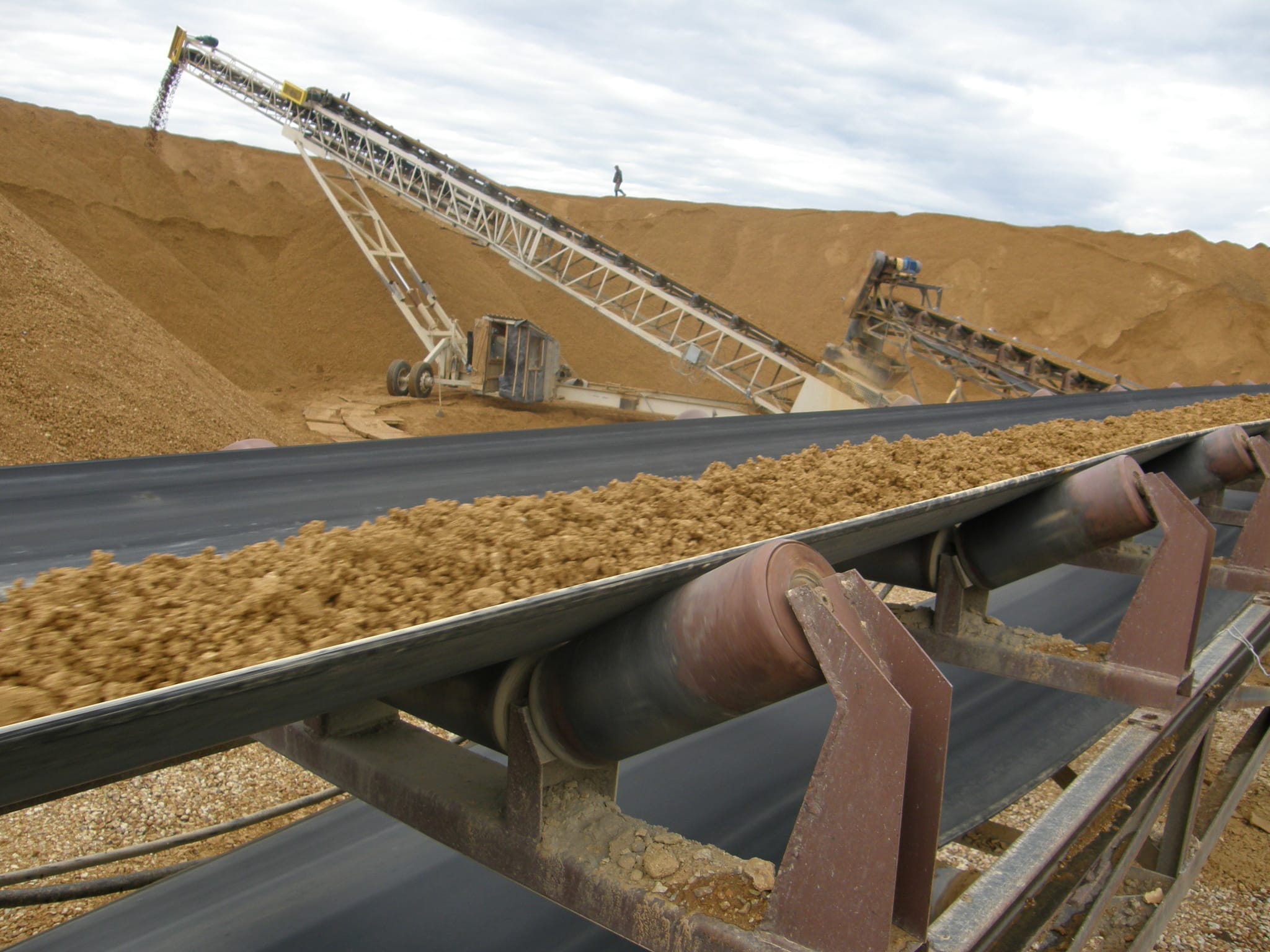 Conveyor carrying ore toward stacking conveyors and stockpiles at a mining-scale plant