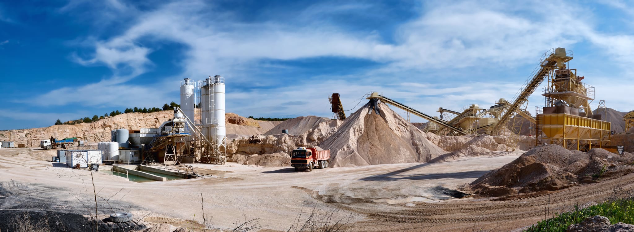 Mineral processing plant with conveyors, stockpiles and screening equipment under open sky