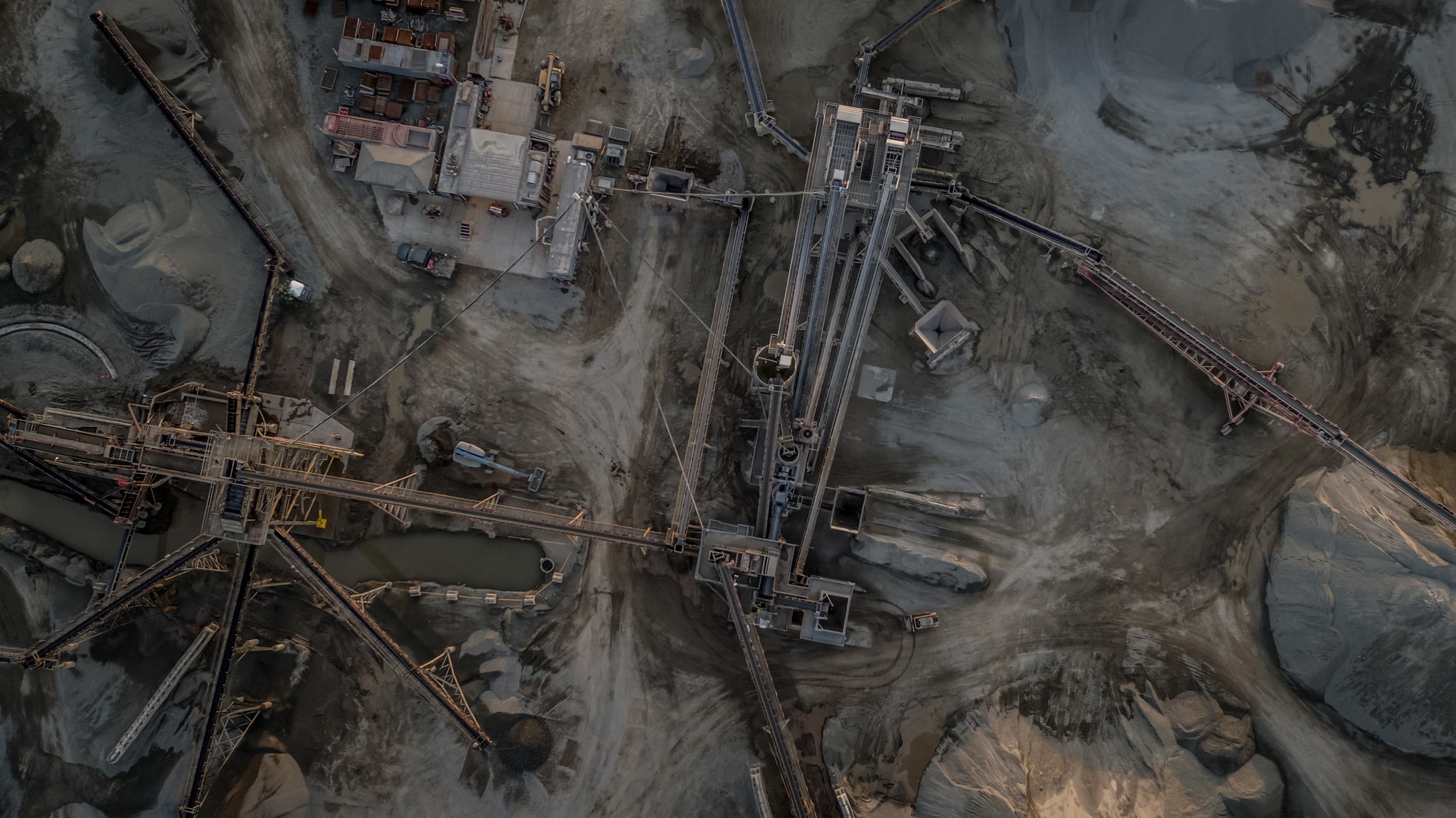 Aerial view of a mineral processing plant with conveyors, screening towers and stockpiles